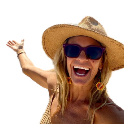 Jennie, laughing, in a wide-brimmed straw hat and sunglasses, one hand raised in greeting.
